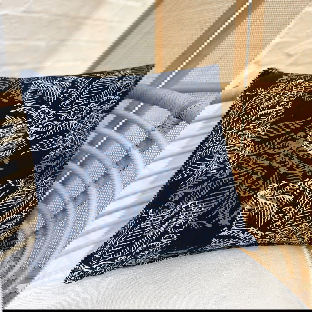 a batik blue nautical fern pillow cover square against a chair