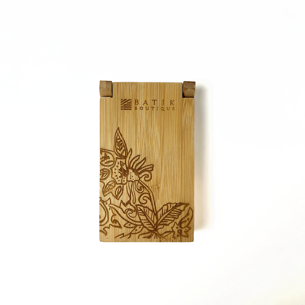 a laser engraved wooden congkak against a white background with th ebatik inspired motif floret