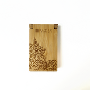 a laser engraved wooden congkak against a white background with th ebatik inspired motif floret