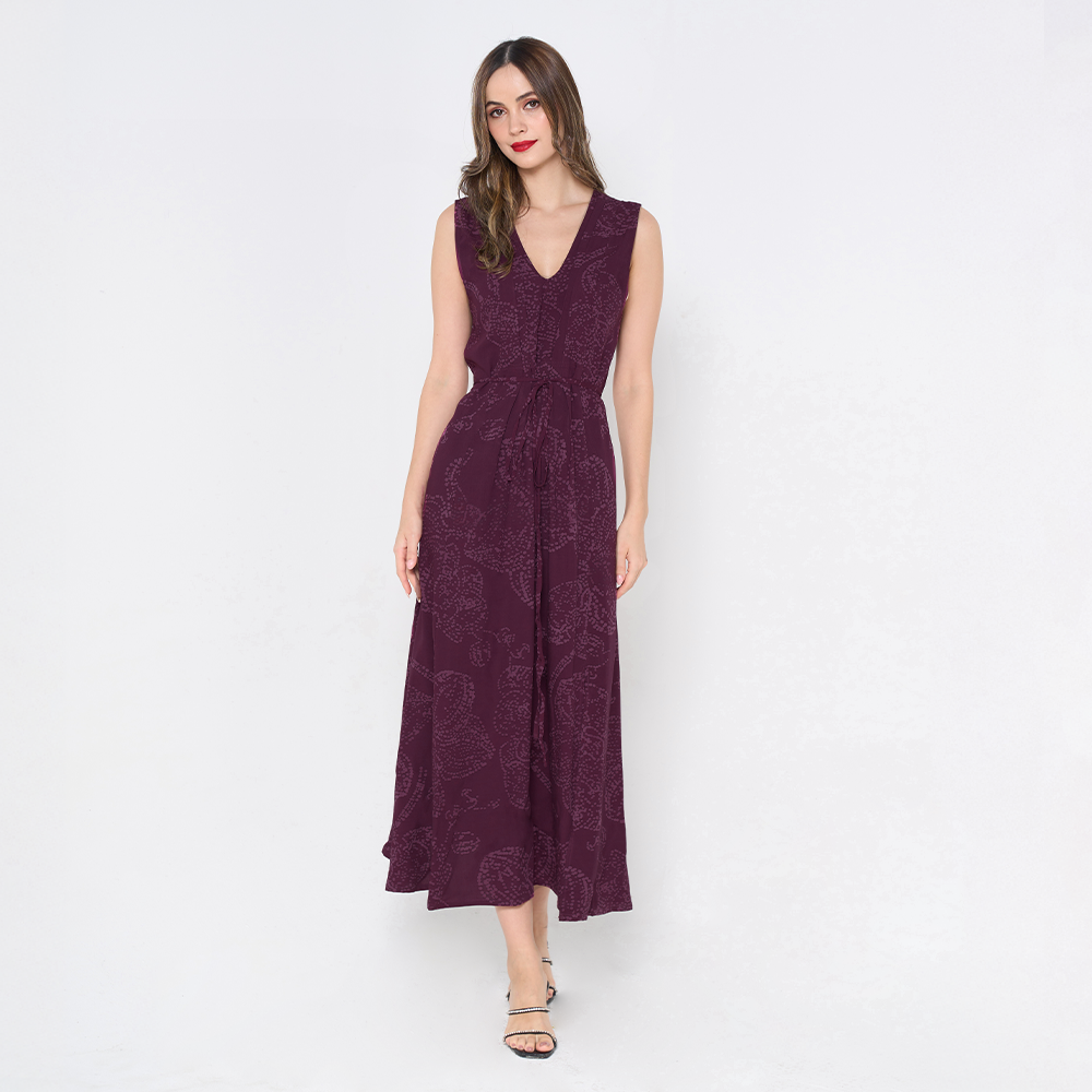 a woman poses in batik dress against a white background in the pattern plum orchid