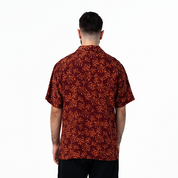 Back view of men's Cuban shirt in maroon coral batik motif.