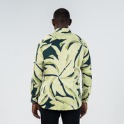 Back view of men's long-sleeved batik shirt in Forest Palma print, featuring bold tropical foliage motif in earthy green tones.