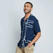 a man wearing a batik shirt against a white background in navy brush