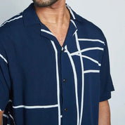 a closeup of batik shirt in the pattern navy brush against a white background