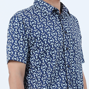 a closeup of a man wearing a batik shirt in the pattern navy kompas against a white background