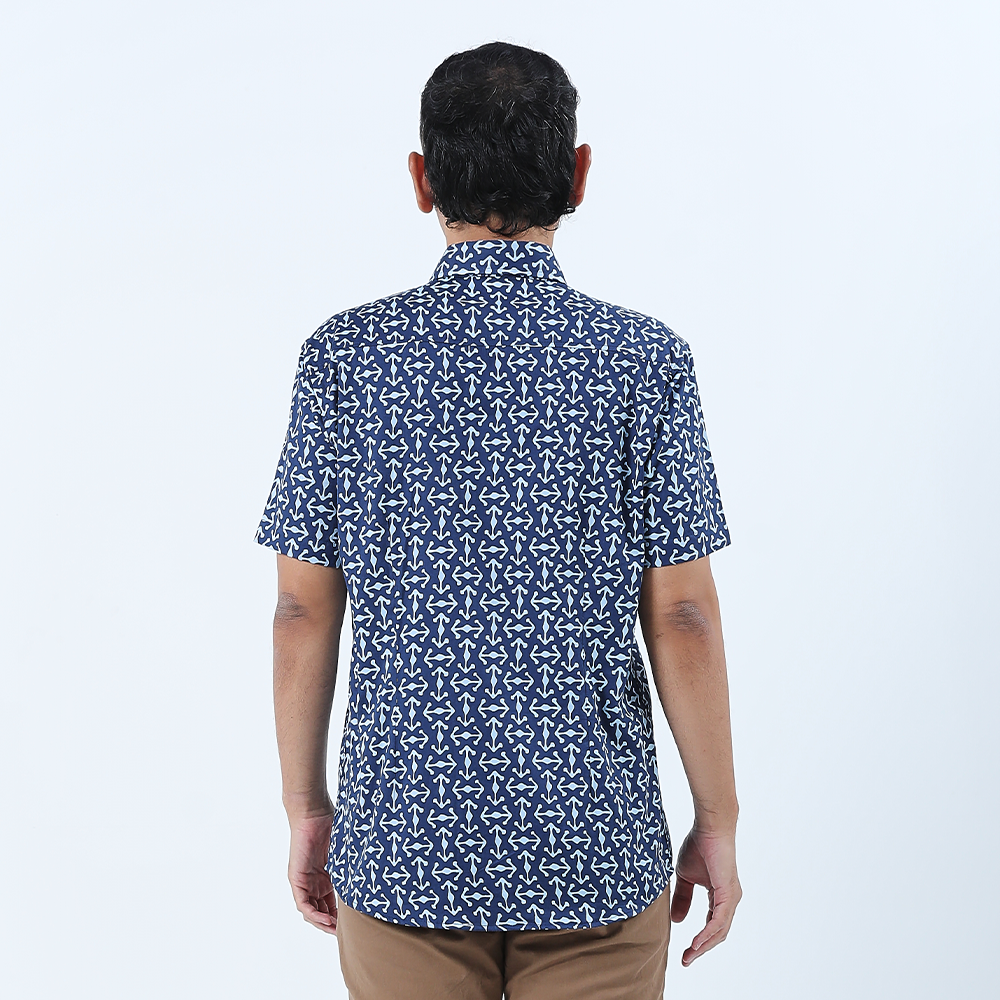 a man showcasing the details on the back of a batik shirt against a white background in navy kompas batik shirt