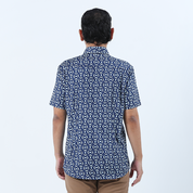 a man showcasing the details on the back of a batik shirt against a white background in navy kompas batik shirt