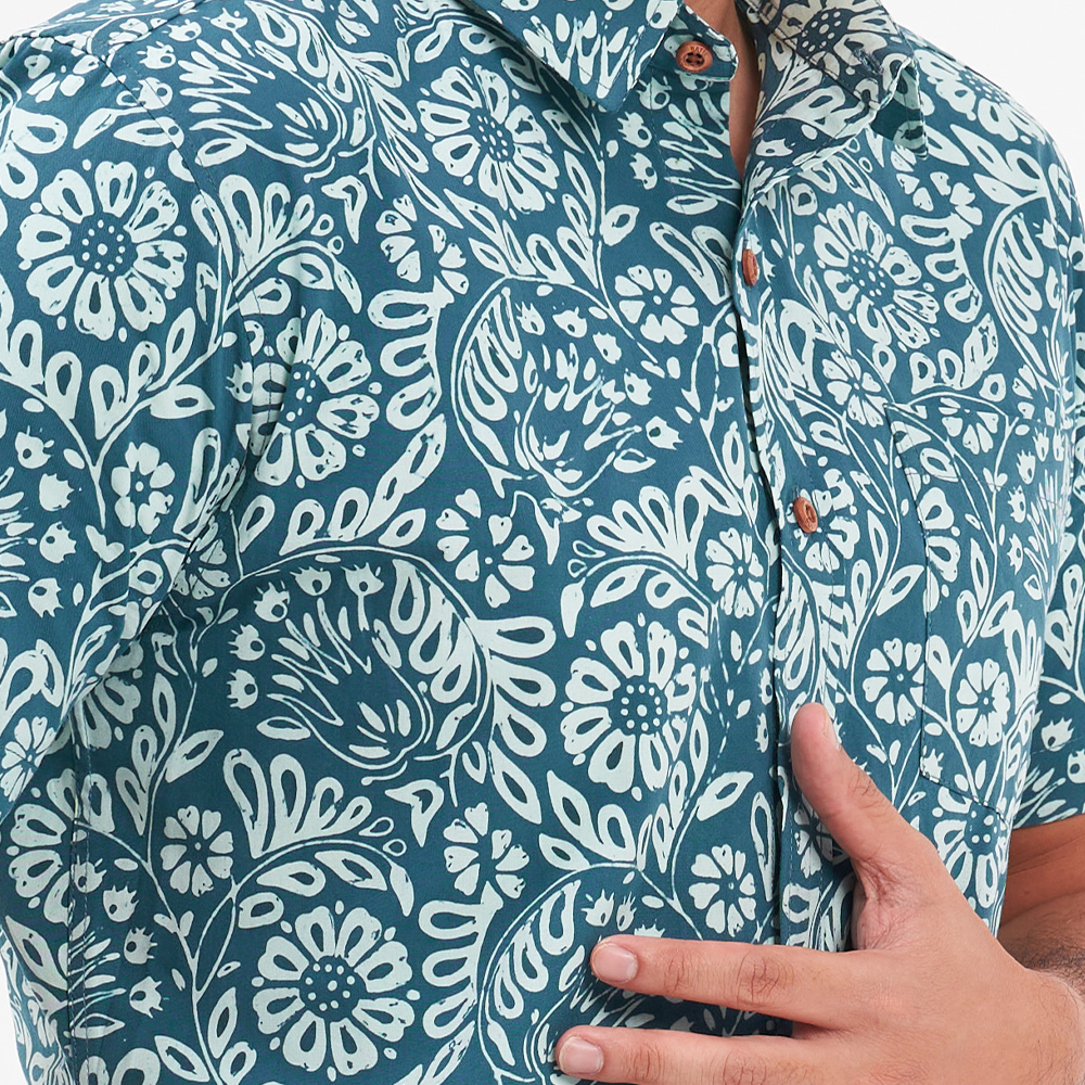 a closeup of a batik shirt in the pattern teal ukir