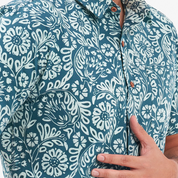 a closeup of a batik shirt in the pattern teal ukir