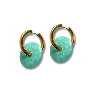 a photo of earrings handmade by refugees in the color turquoise and gold