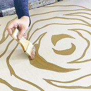 an artisan in the process of waxing in batik using a brush