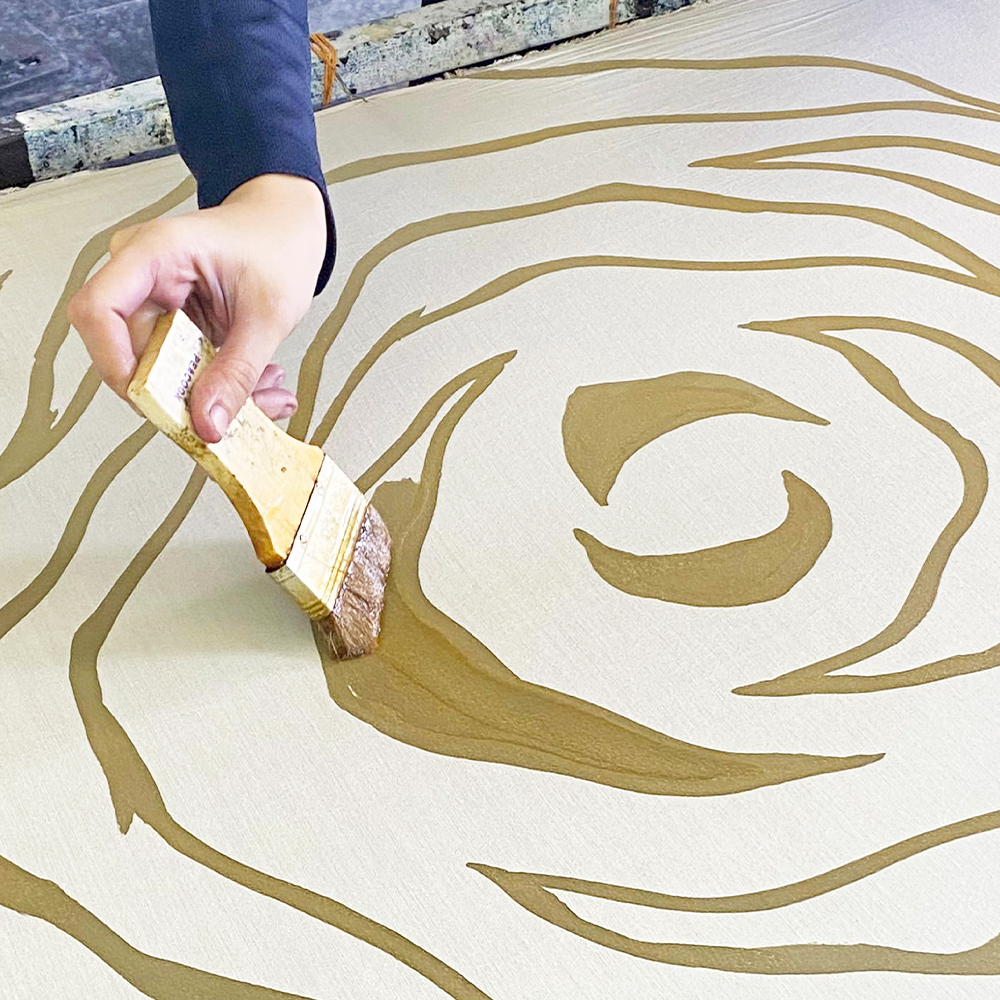 an artisan in the process of waxing in batik using a brush