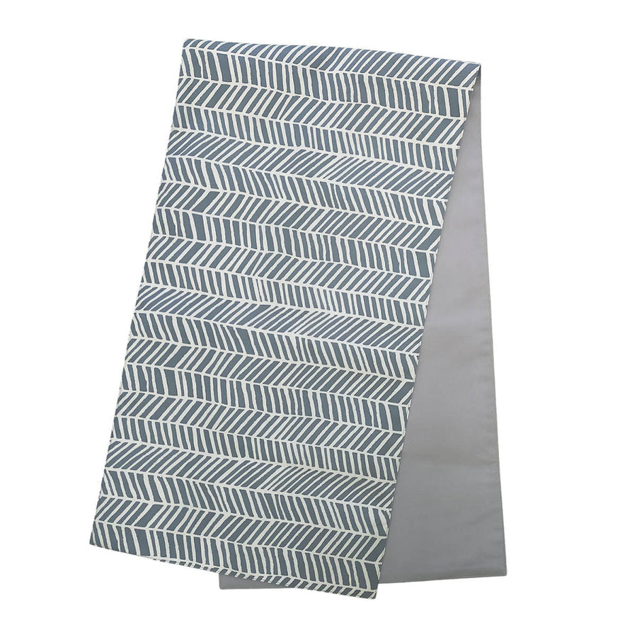 a batik table runner in the pattern grey banana leaf against a white background