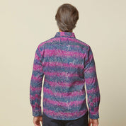 A photo of man standing in front of beige background wearing maroon long sleeved shirt facing back