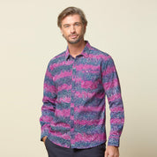 A photo of man standing in front of beige background wearing maroon long sleeved shirt facing front
