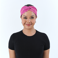 a female model posing in a batik headband in the pattern fuchsia paw