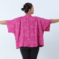 a photo of a model posing showing the details of the cardigan kimono in the pattern fuchsia palm