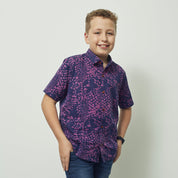 A boy wearing batik shirt in purple bintik pattern