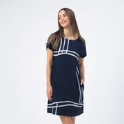 a woman posing happily against a white background in a blue batik modern dress in the pattern navy brush