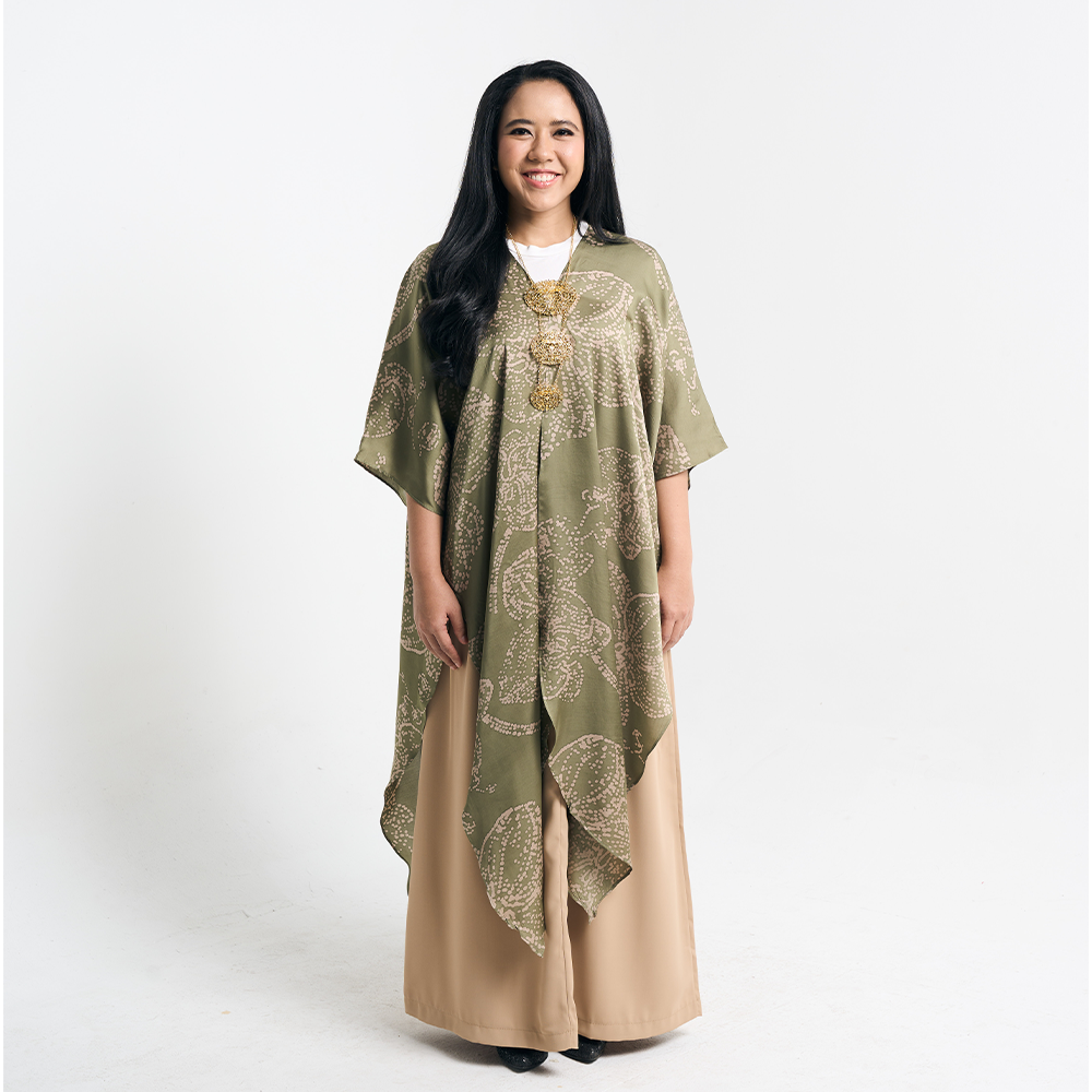 A full-body shot of the model in the batik kimono, styled with beige pants and a statement necklace