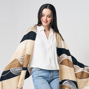 a women is styling handpainted batik scarf while standing in front of white background