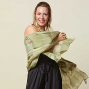Woman wearing long batik scarf in olive cotton silk.