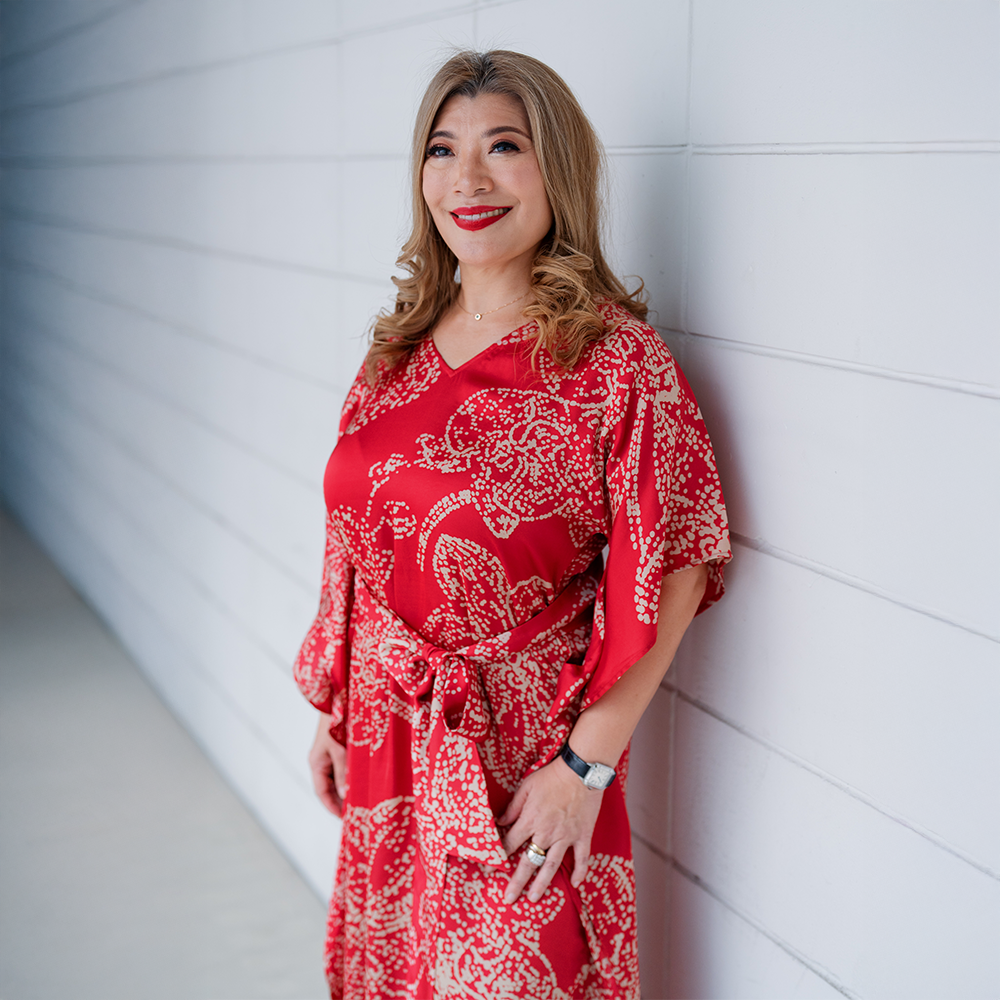 a woman posing in a lifestyle picture in batik caftan dress in crimson orchid