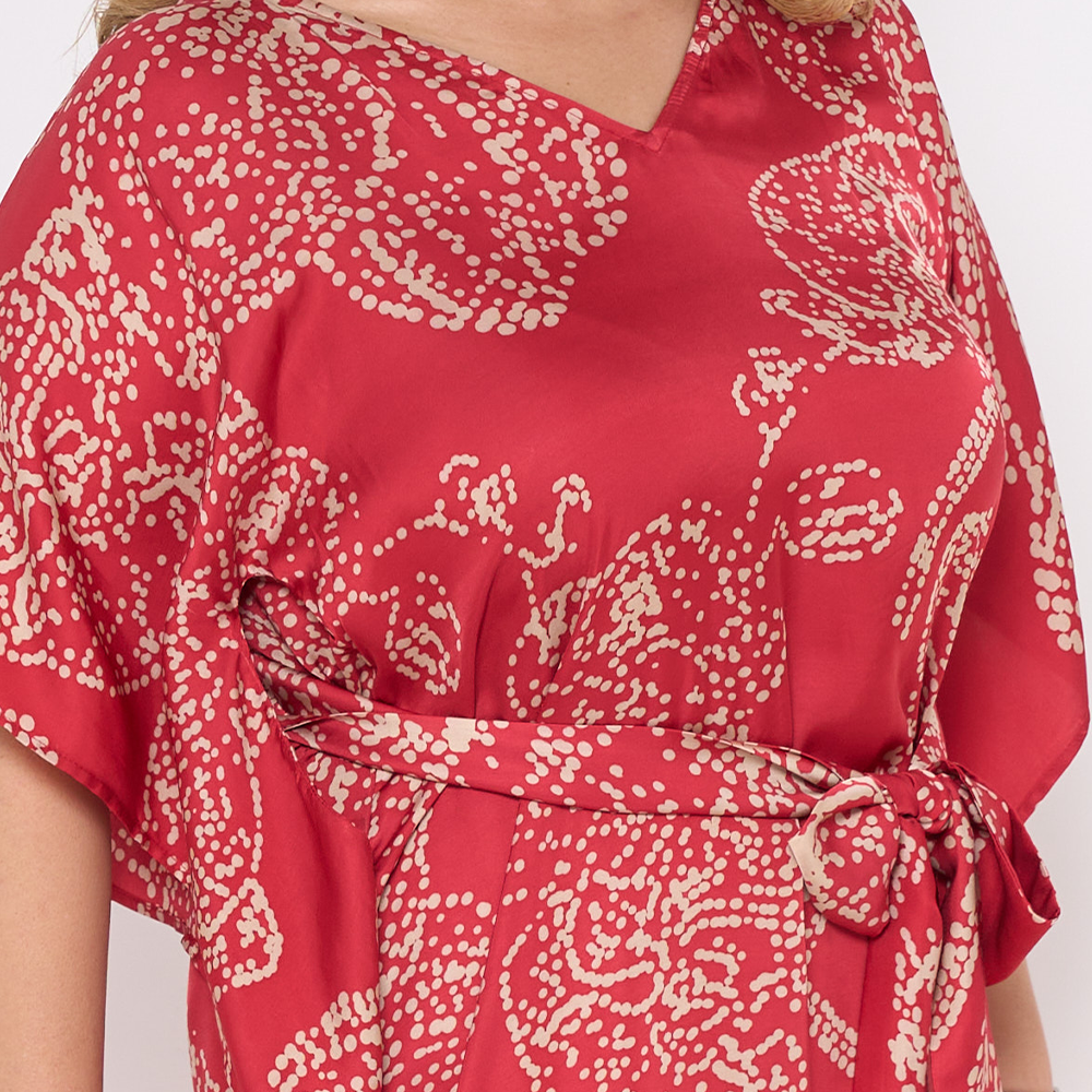 a closeup of crimson orchid against a white background in batik caftan dress in crimson orchid