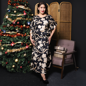 a woman posing in a christmas setting in a batik caftan dress 