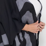 a closeup shot of a batik cardigan kimono in front of a white background in the pattern grey rose