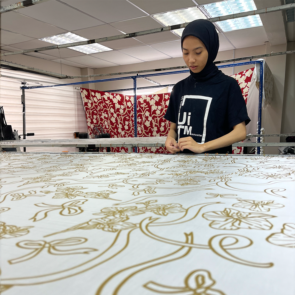 artisan in the process of setting up batik fabric in the pattern fleur