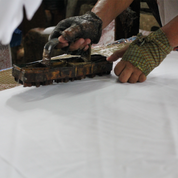 artisan in the process of blocking in batik