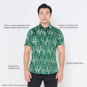 a male model posing in a batik shirt against a white background in green tiffin