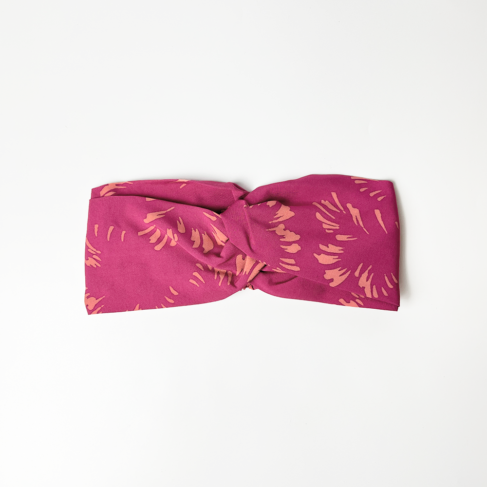 a whitebox headband in the pattern fuchsia paw against a white background
