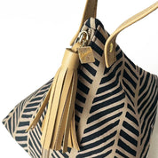 Close-up of Batik Boutique’s Ketupat Bag showcasing the Black Banana Leaf print, gold zipper, and signature charm.