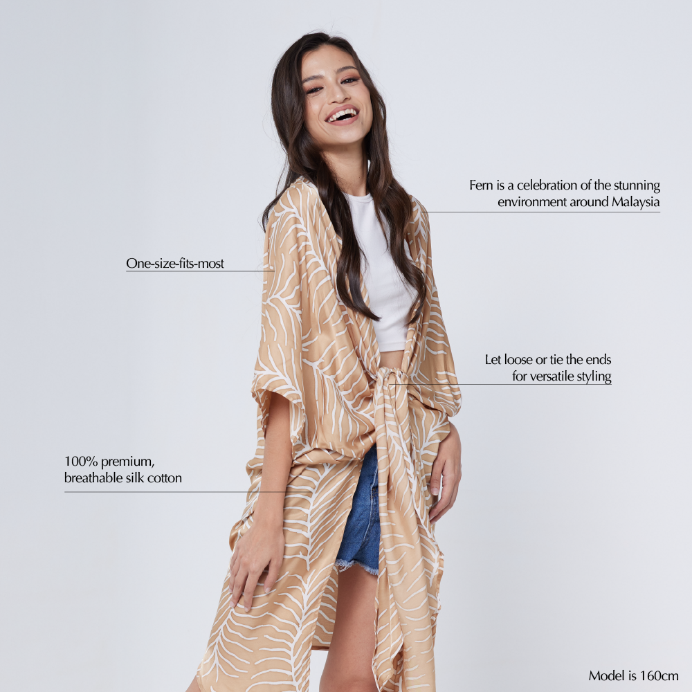 a female model in a batik kimono in the pattern latte fern against a white background