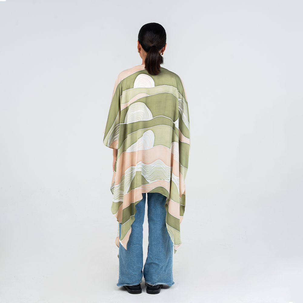 Back view of a woman wearing Batik Boutique's Kimono in Moss Bukit print, showcasing soft green and beige batik patterns inspired by Malaysian hills