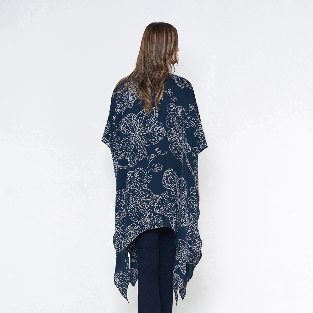 a woman posing with her back to the camera to showcase the details of the batik kimono in navy orchid