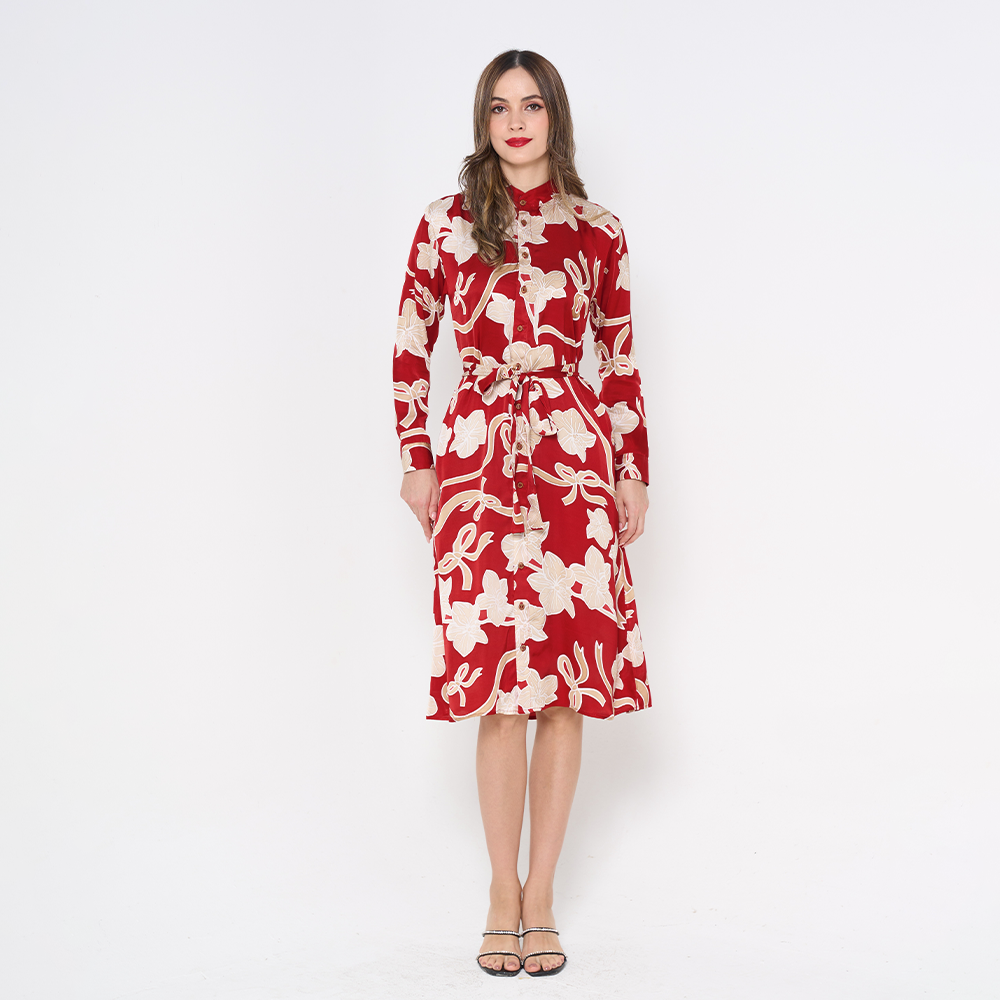 a woman poses in batik long shirt dress in the pattern ruby fleur against a white background