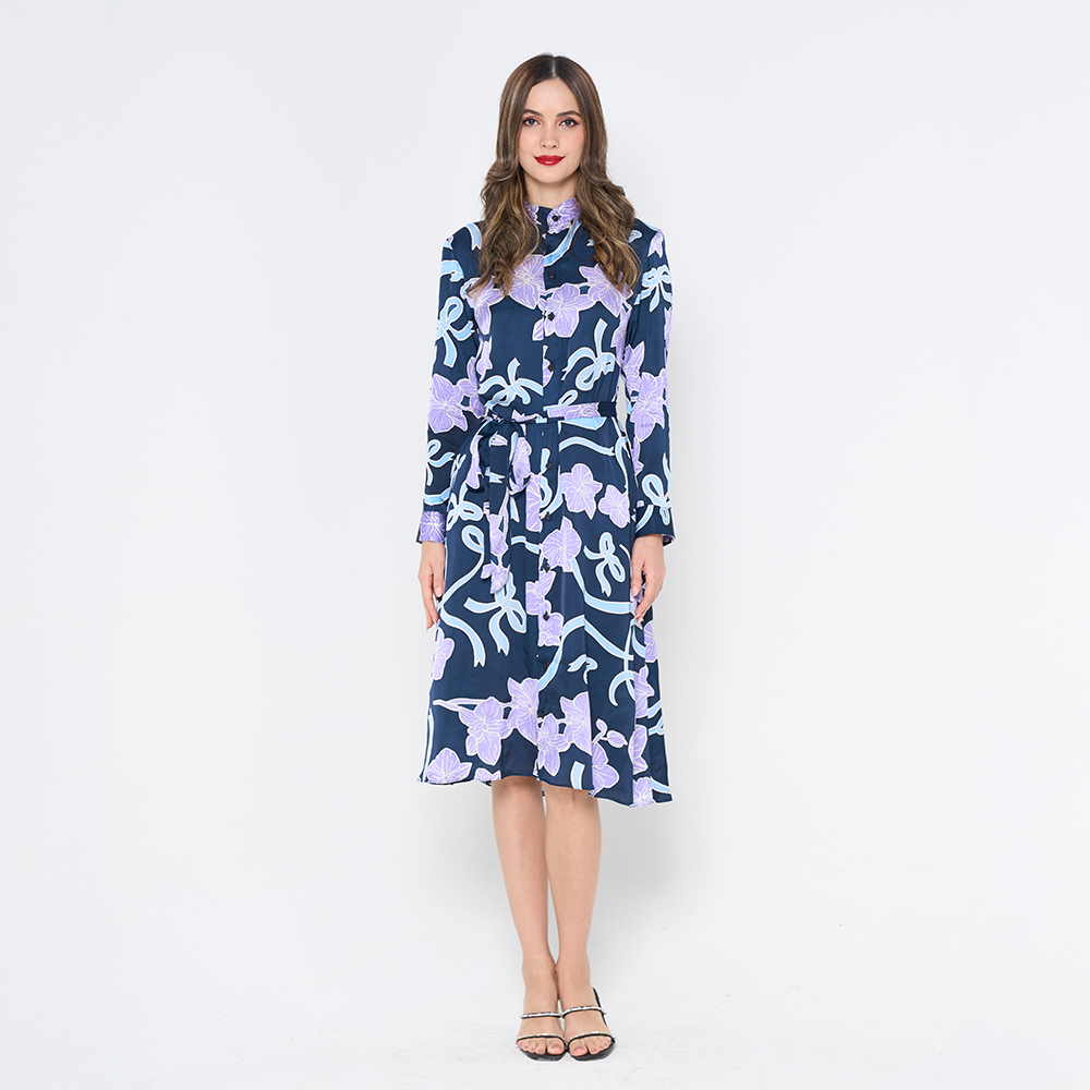 a woman in long shirt dress in the pattern sapphire fleur against a white background