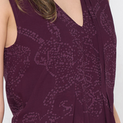 a closeup of batik dress against a white background in the pattern plum orchid