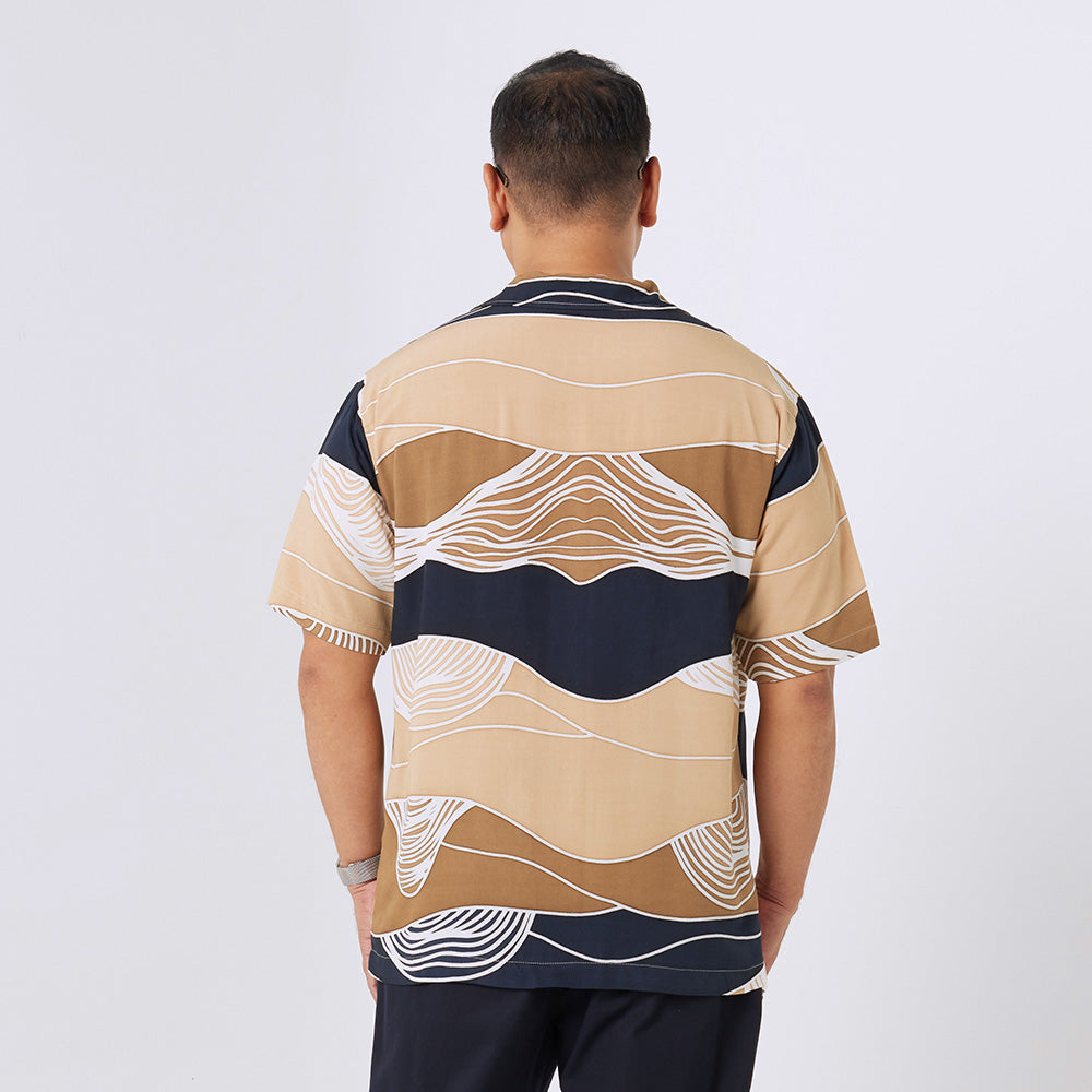 a man standing in front of white background styling batik cuban shirt in black bukit pattern 