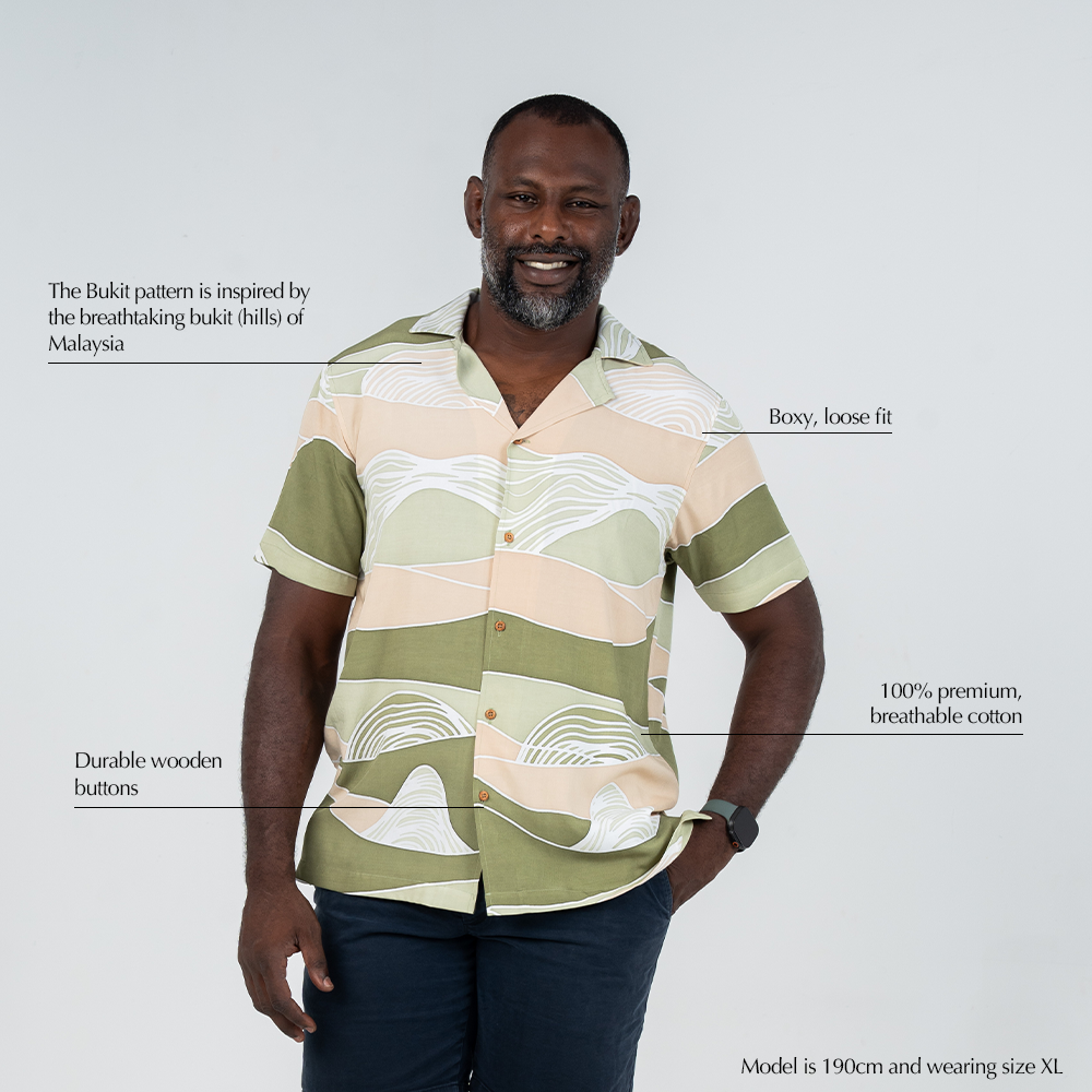 Feature highlights of the Moss Bukit men's batik shirt from Batik Boutique, including 100% breathable cotton, wooden buttons, boxy fit, and Bukit-inspired motif