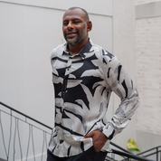 a man wearing a silk cotton shirt in the pattern starry palma in a lifestyle photo