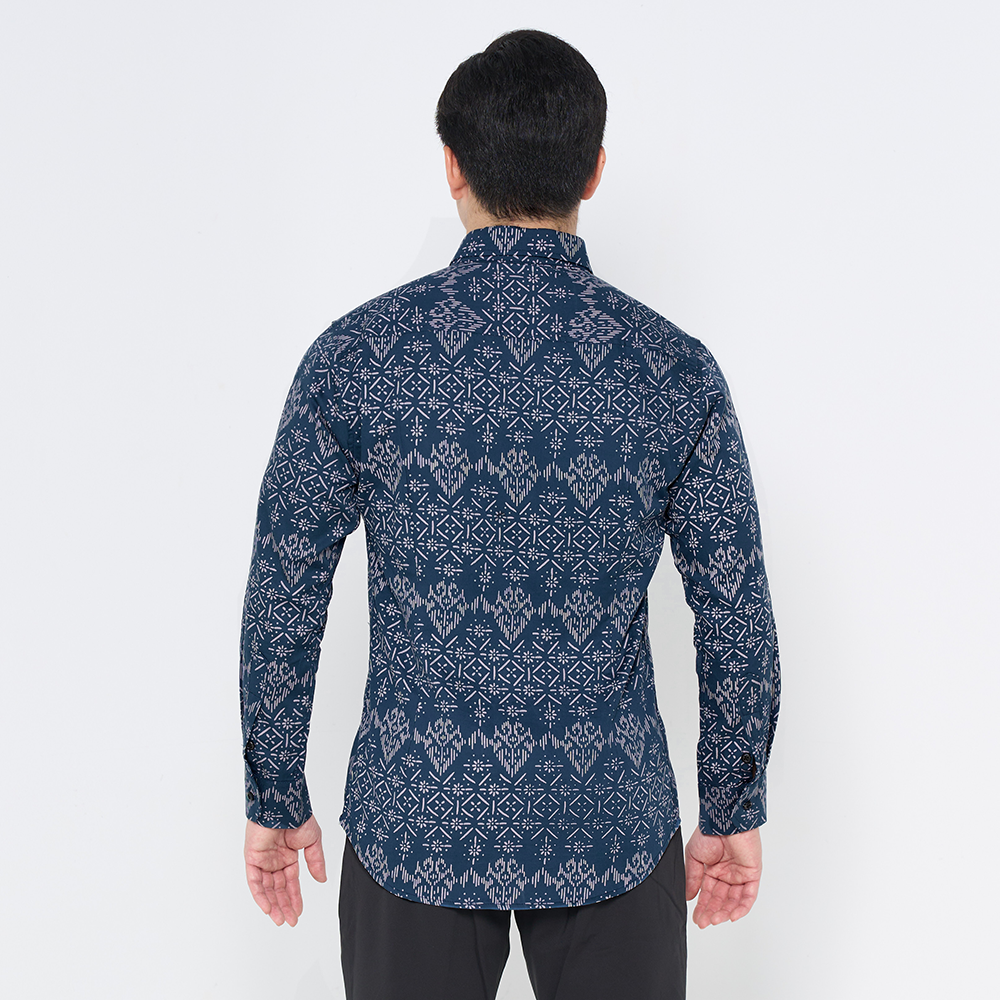 a man facing away from the camera in a long sleeved shirt against a white background in the pattern navy anyam 