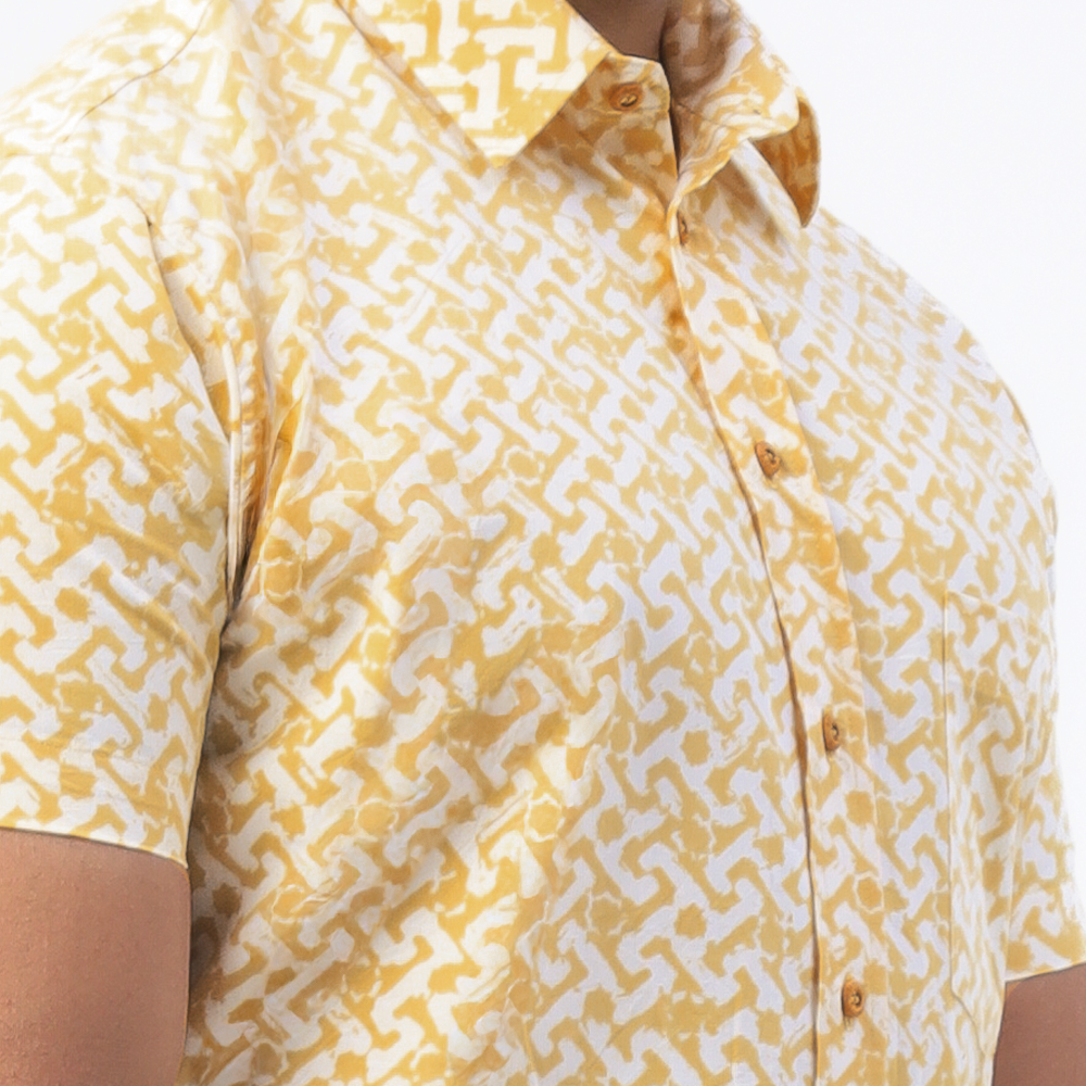 a closeup of batik shirt in the pattern mustard arabesque