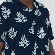 a closeup of navy olive leaf batik shirt in cuban cutting against a white background