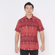 a male model posing in a batik shirt against a white background in red anyam 