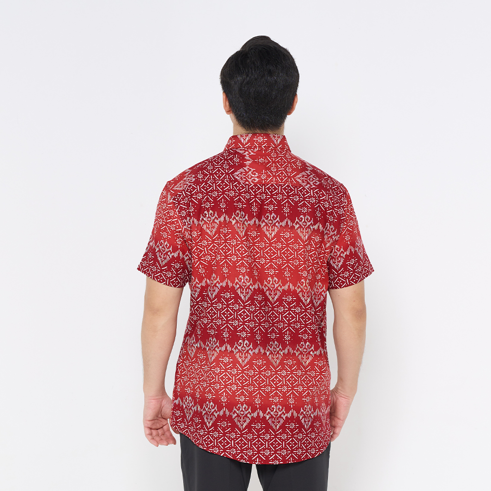 a male model poses in a batik shirt against a white background in the batik shirt red anyam