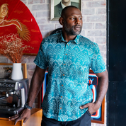 a man modeling a turquoise anyam batik shirt in a lifestyle photo